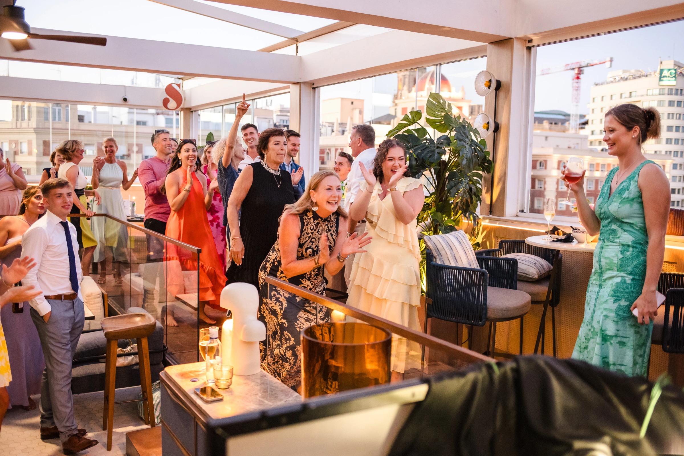 Guests mingling and celebrating at a rooftop reception, some raising their arms in joy and dancing. — Wedding at Hotel Only You, Malaga, spain
