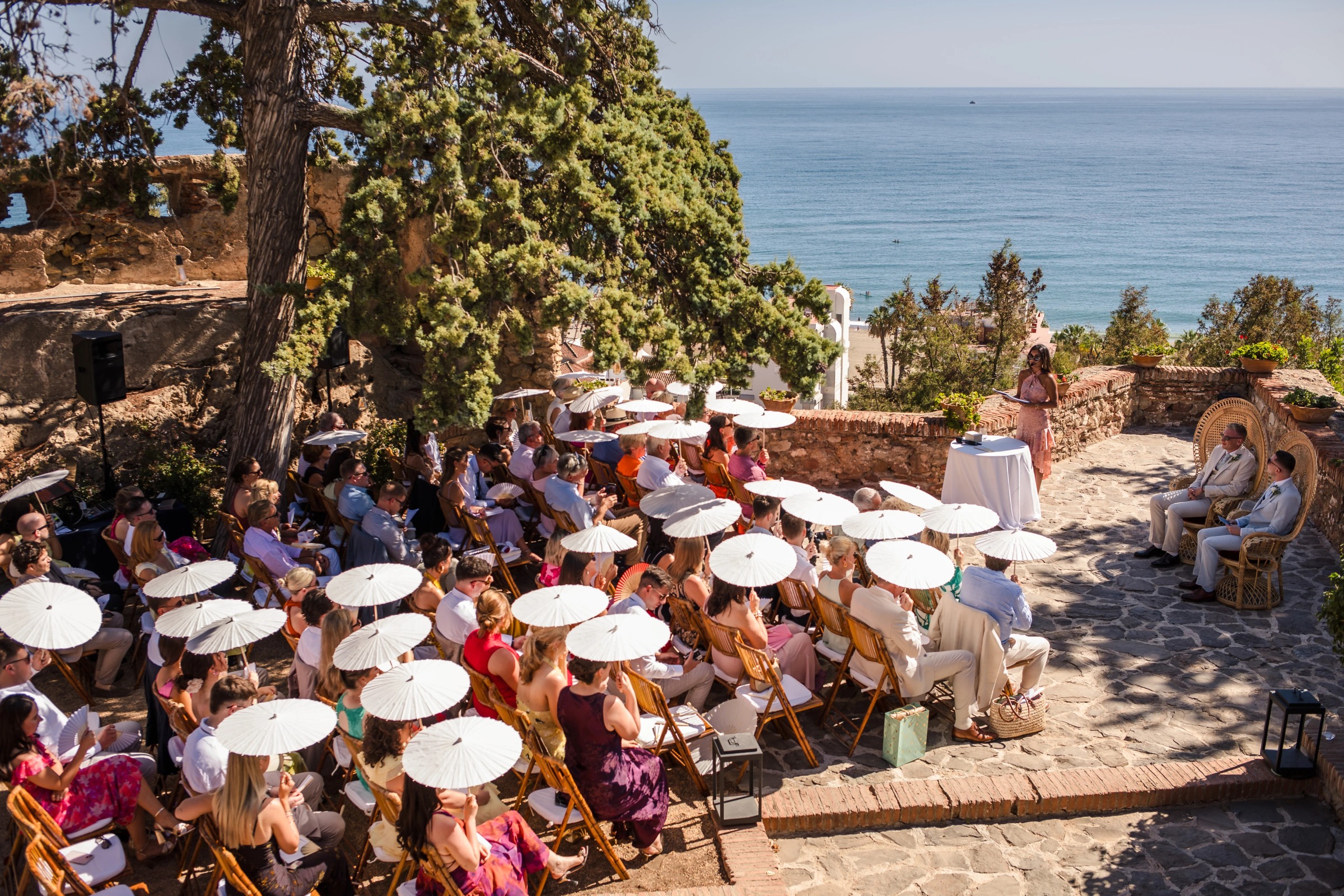 Guests seated at round tables during an outdoor reception meal with sea views. — Wedding at Hotel Only You, Malaga, spain