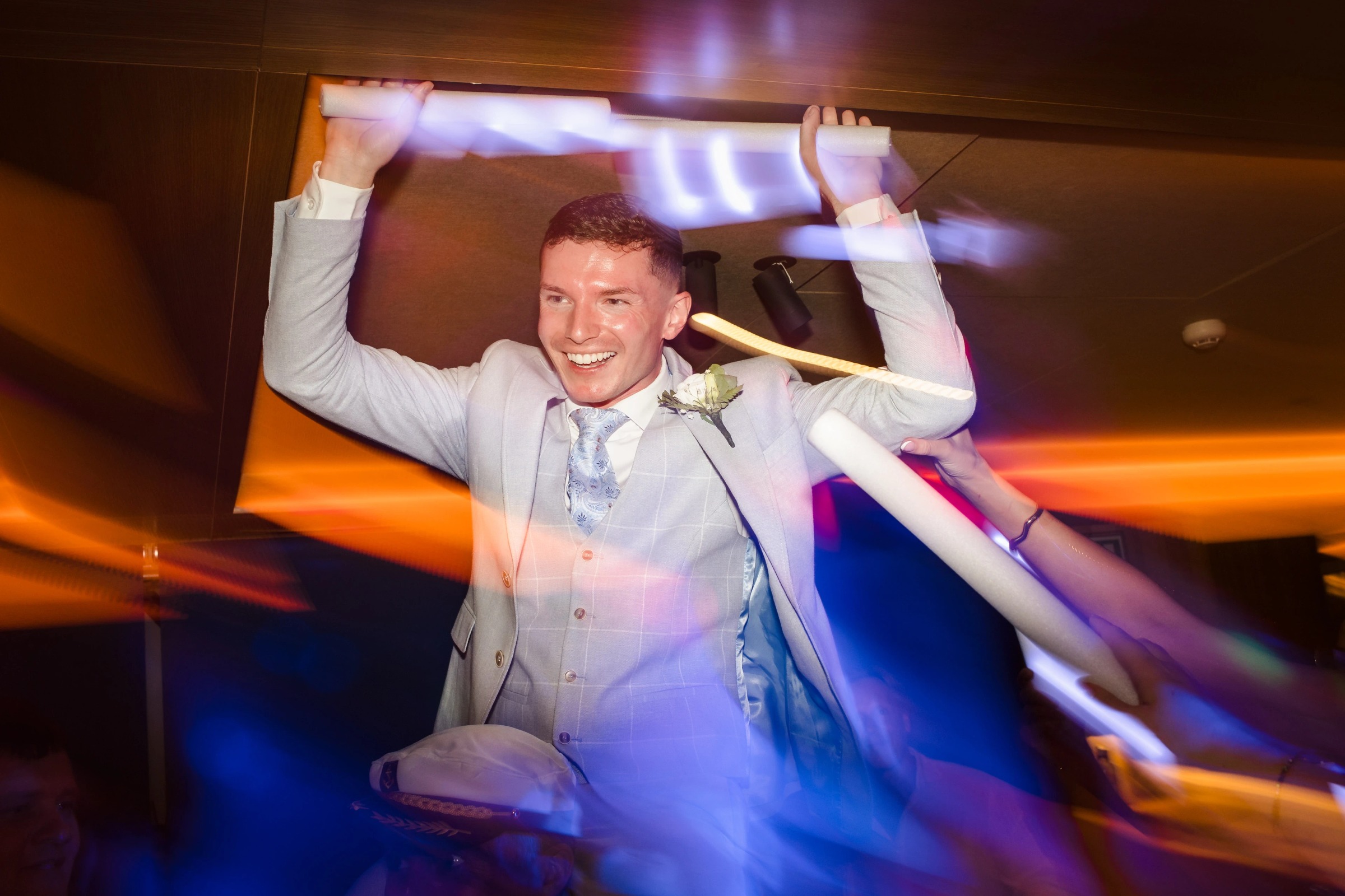 Man in light suit celebrating with arms raised overhead at an indoor reception. — Wedding at Hotel Only You, Malaga, spain