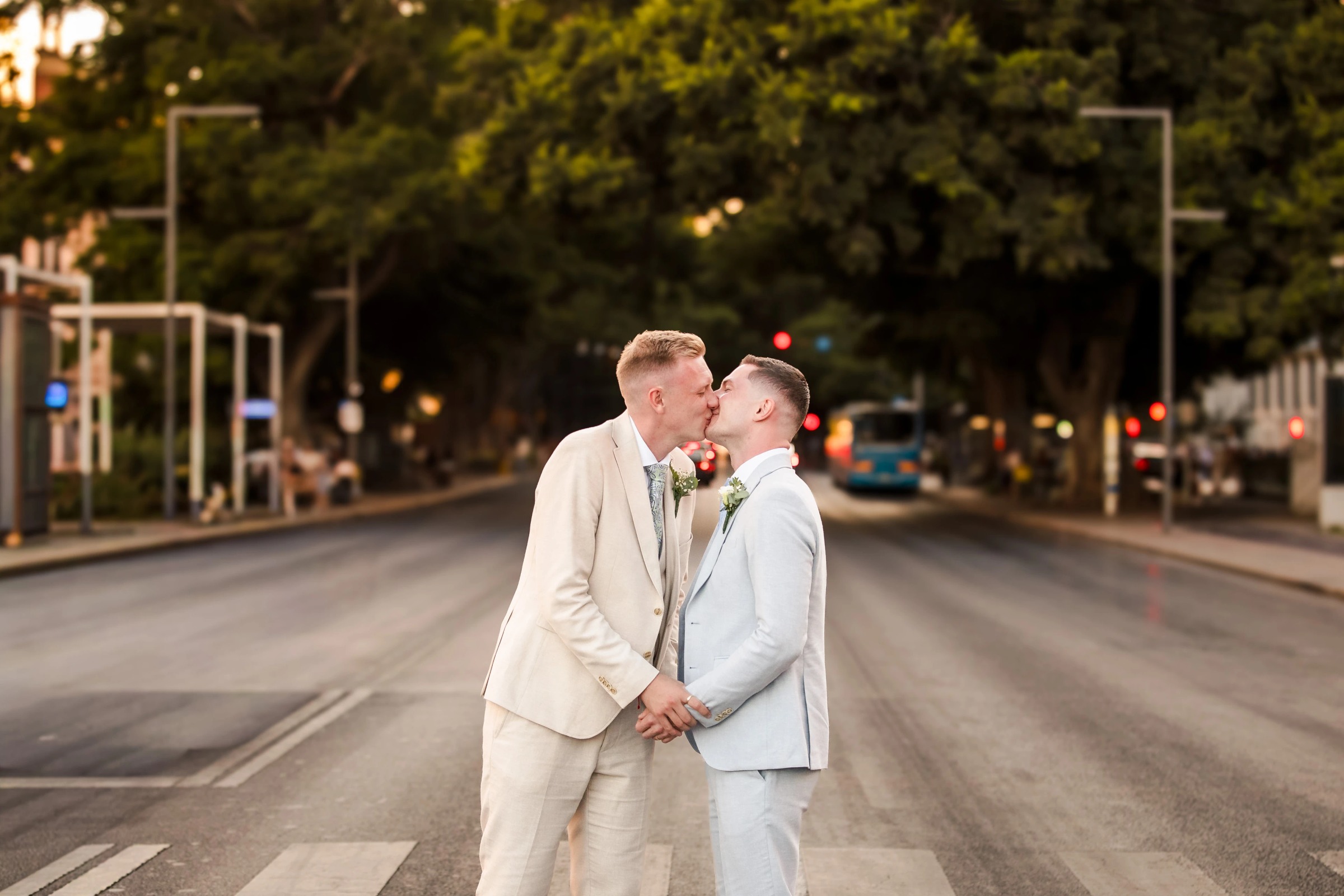 Two grooms kiss on a city street crosswalk during golden hour. — Wedding at Hotel Only You, Malaga, spain