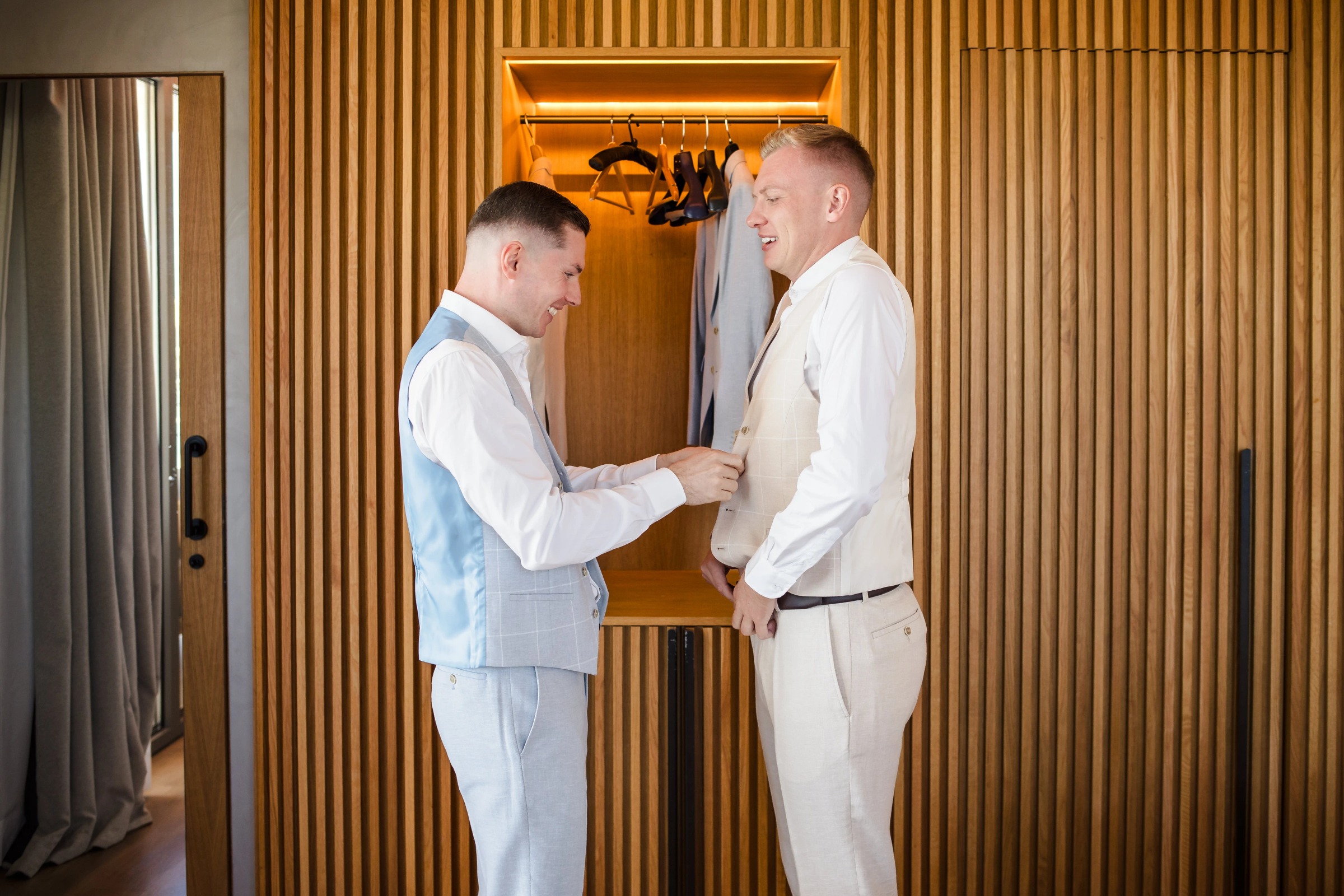 Two men in light suits shake hands and exchange vows or greetings in a modern interior. — Wedding at Hotel Only You, Malaga, spain