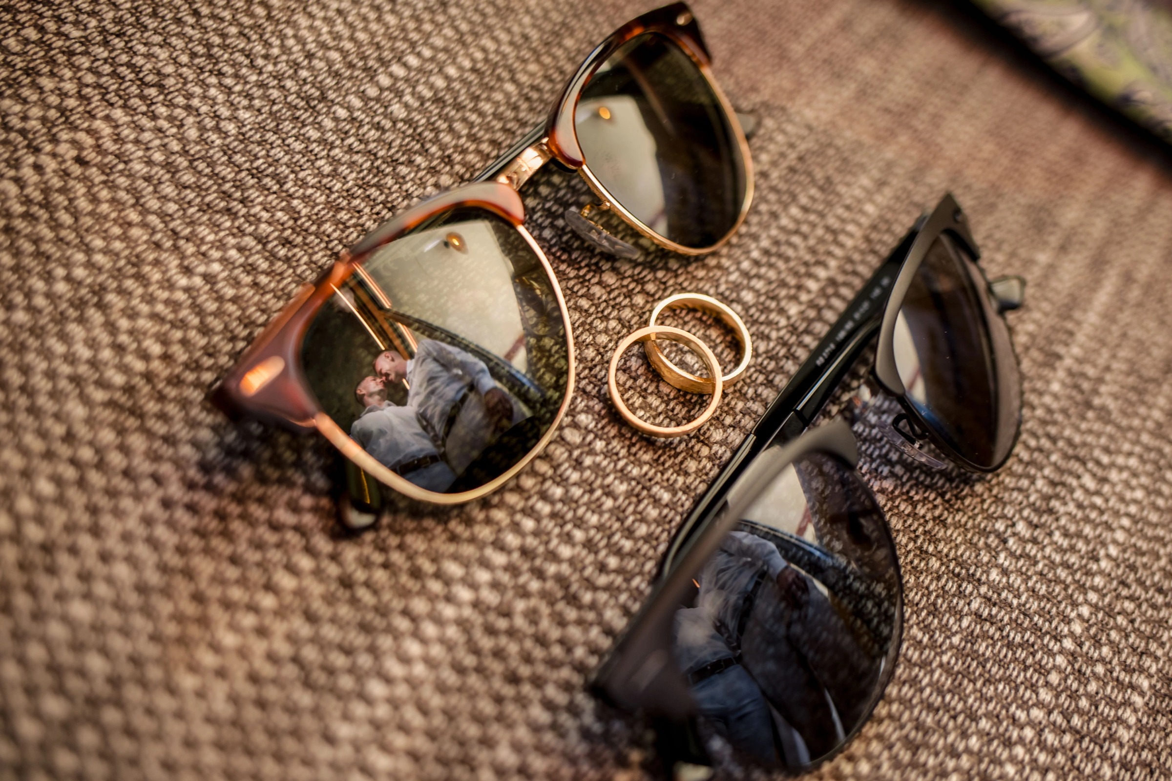 Wedding rings and sunglasses arranged on textured fabric for a detail photograph. — Wedding at Hotel Only You, Malaga, spain
