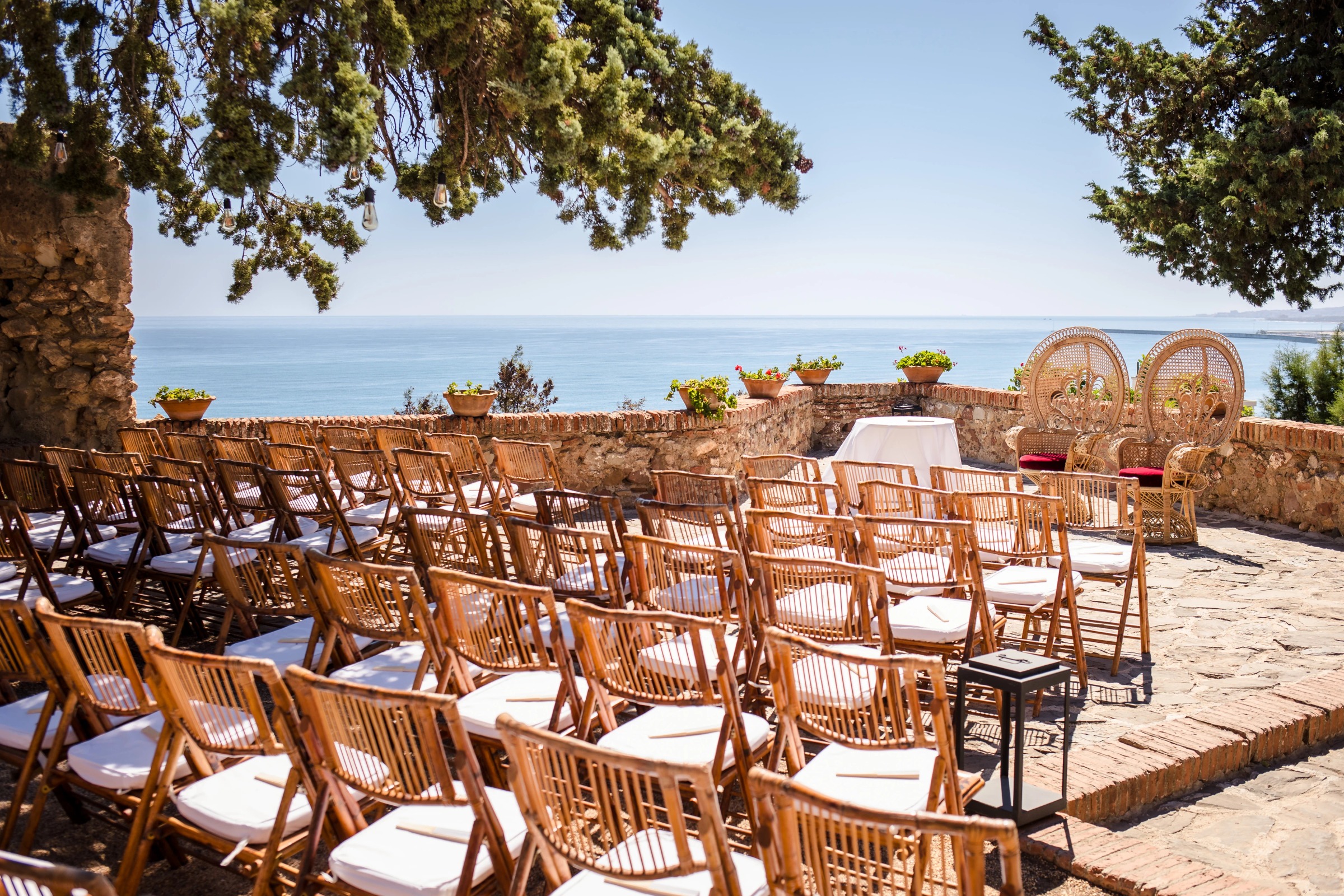 Wooden chairs arranged in rows facing the sea, set up for an outdoor ceremony. — Wedding at Hotel Only You, Malaga, spain